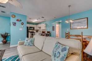 Relax in this inviting living space with a comfortable sofa, dining table, and fully equipped kitchen.