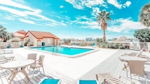A pool area with lounge chairs and tables, a building with a red roof, and palm trees. - Footsteps away from beautiful beaches 🏖🏝⛱ (Navarre)