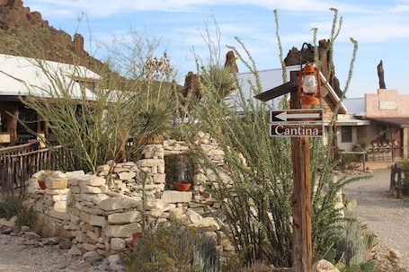 A rustic stone wall with a wooden sign pointing to Cantina.
