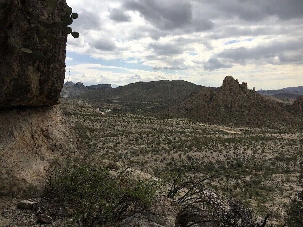 A desert landscape with rocky terrain and sparse vegetation.