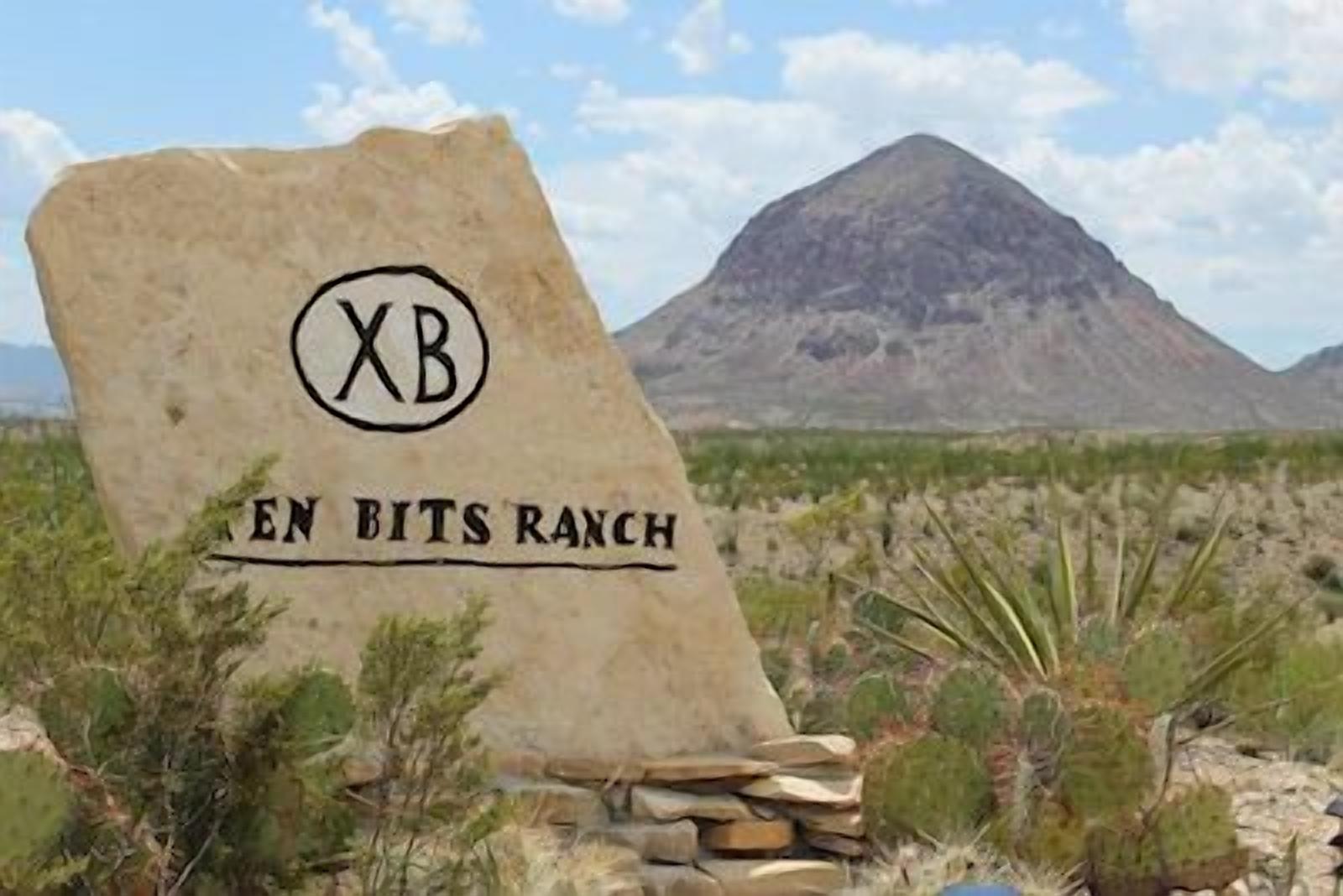 A sign for 'EN BITS RANCH' with a mountain in the background.