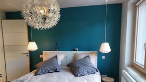 Une chambre à coucher avec un lit, deux lampes de chevet, un radiateur et une fenêtre.