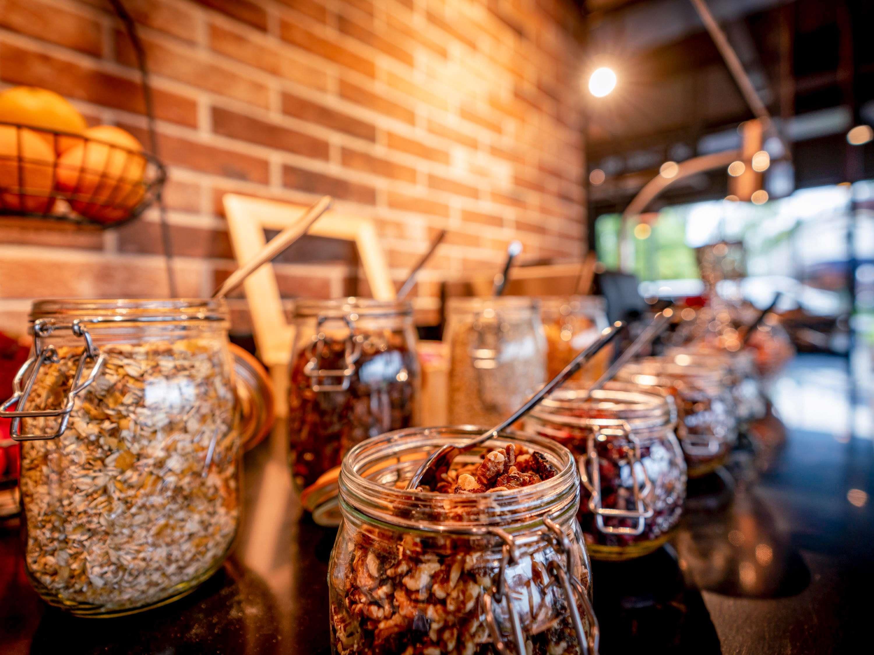 A buffet with various food items in glass jars.