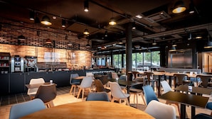 A modern cafe with brick walls, a bar area, and ample seating.
