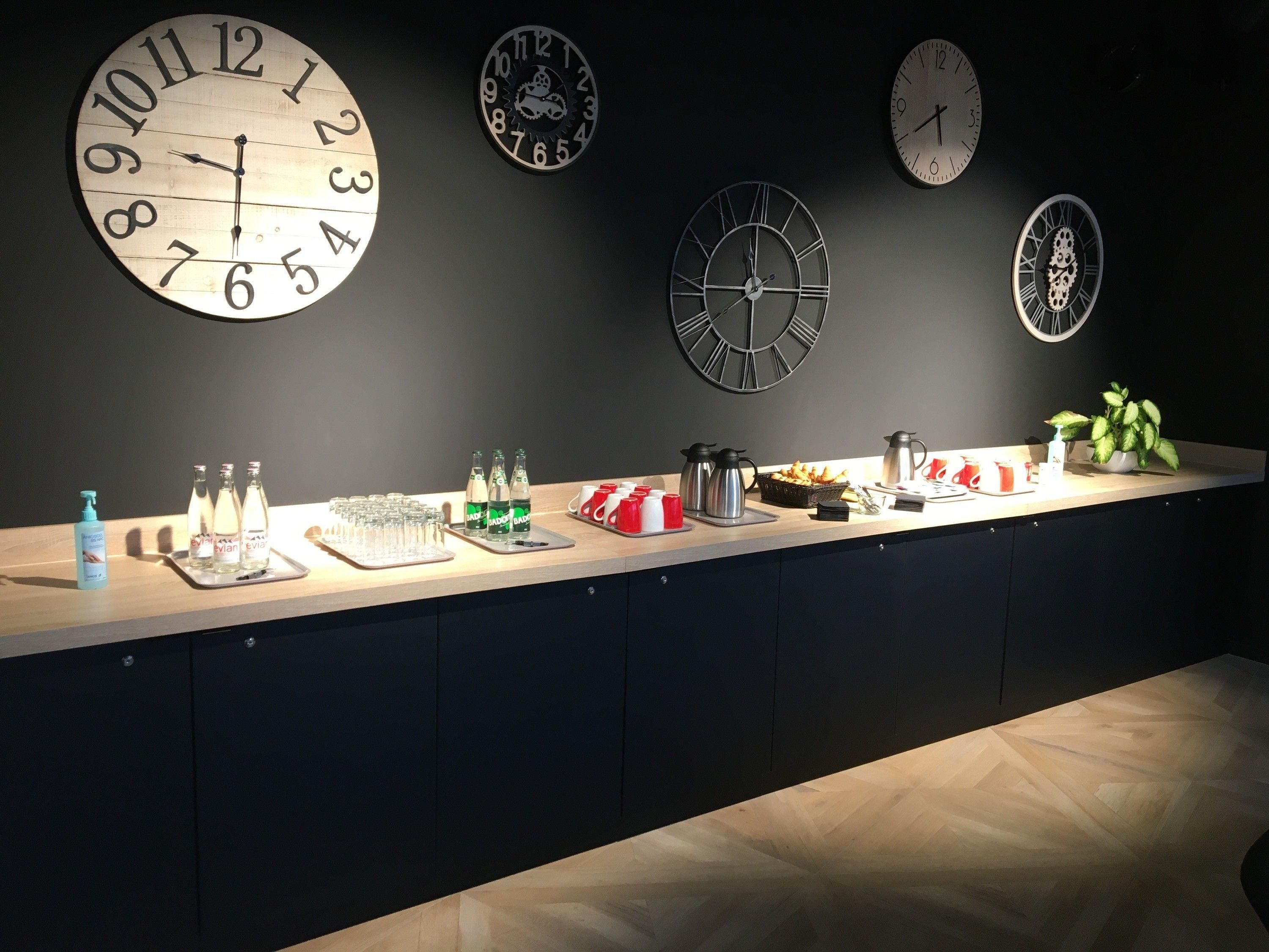 A reception area with a counter displaying various amenities including bottles, cups, and a plant.