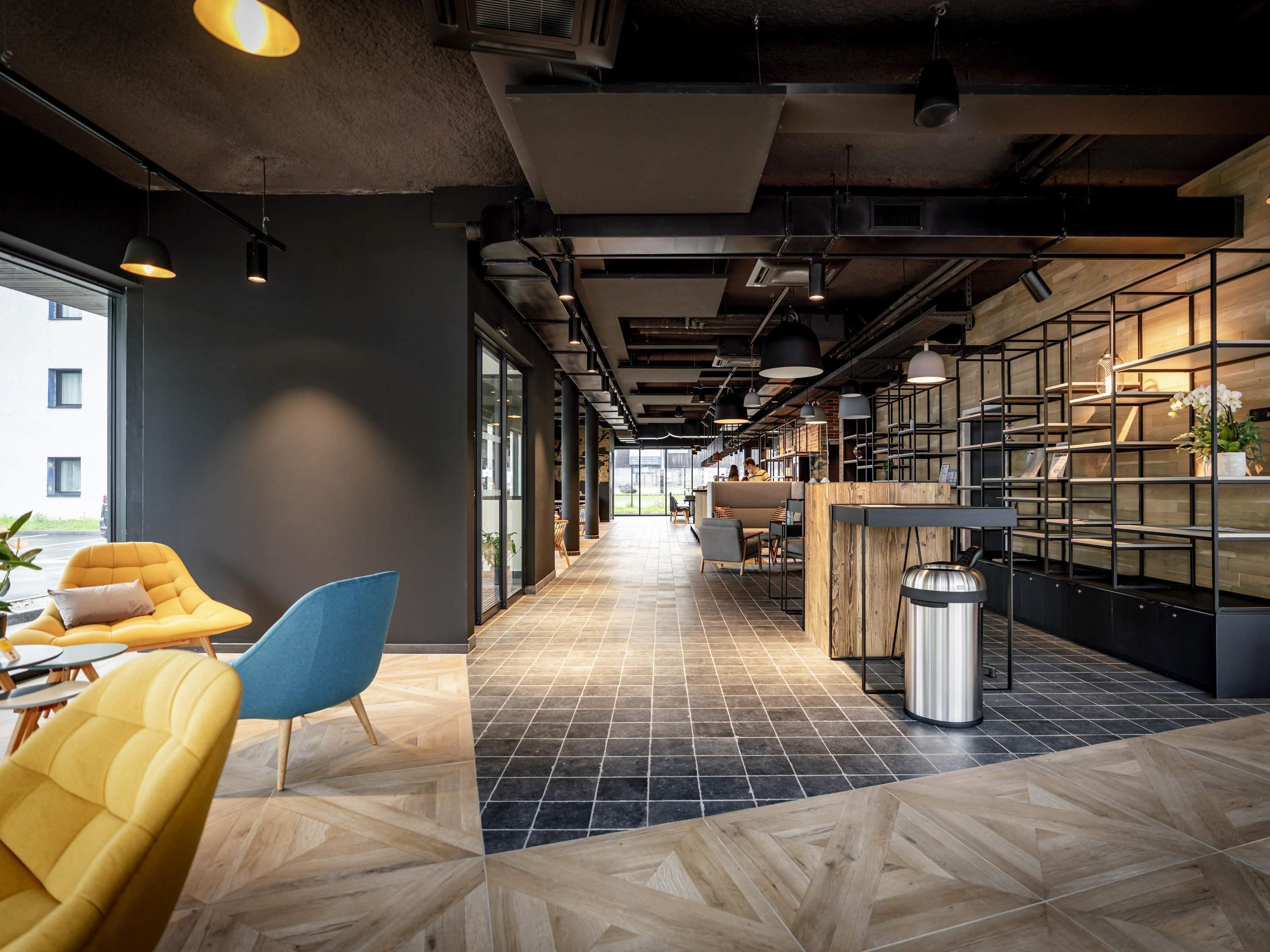 Un intérieur moderne avec un long couloir, des espaces de détente et un coin cuisine.