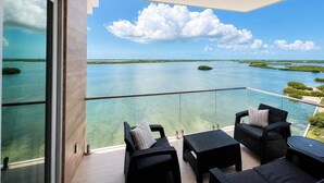 Un balcón con vistas despejadas a un paisaje tropical, que incluye agua y vegetación.