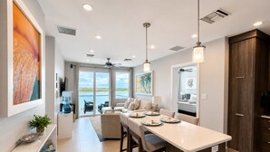 Una cocina moderna con una isla central, un comedor y vistas al exterior.