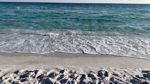 Une plage avec une eau cristalline et un rivage sablonneux.