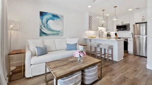 Un salon moderne avec un canapé blanc, une table basse en bois et un ventilateur de plafond.