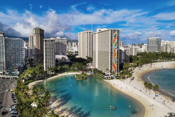 Un paysage urbain côtier avec de hauts immeubles, une plage et un port de plaisance.