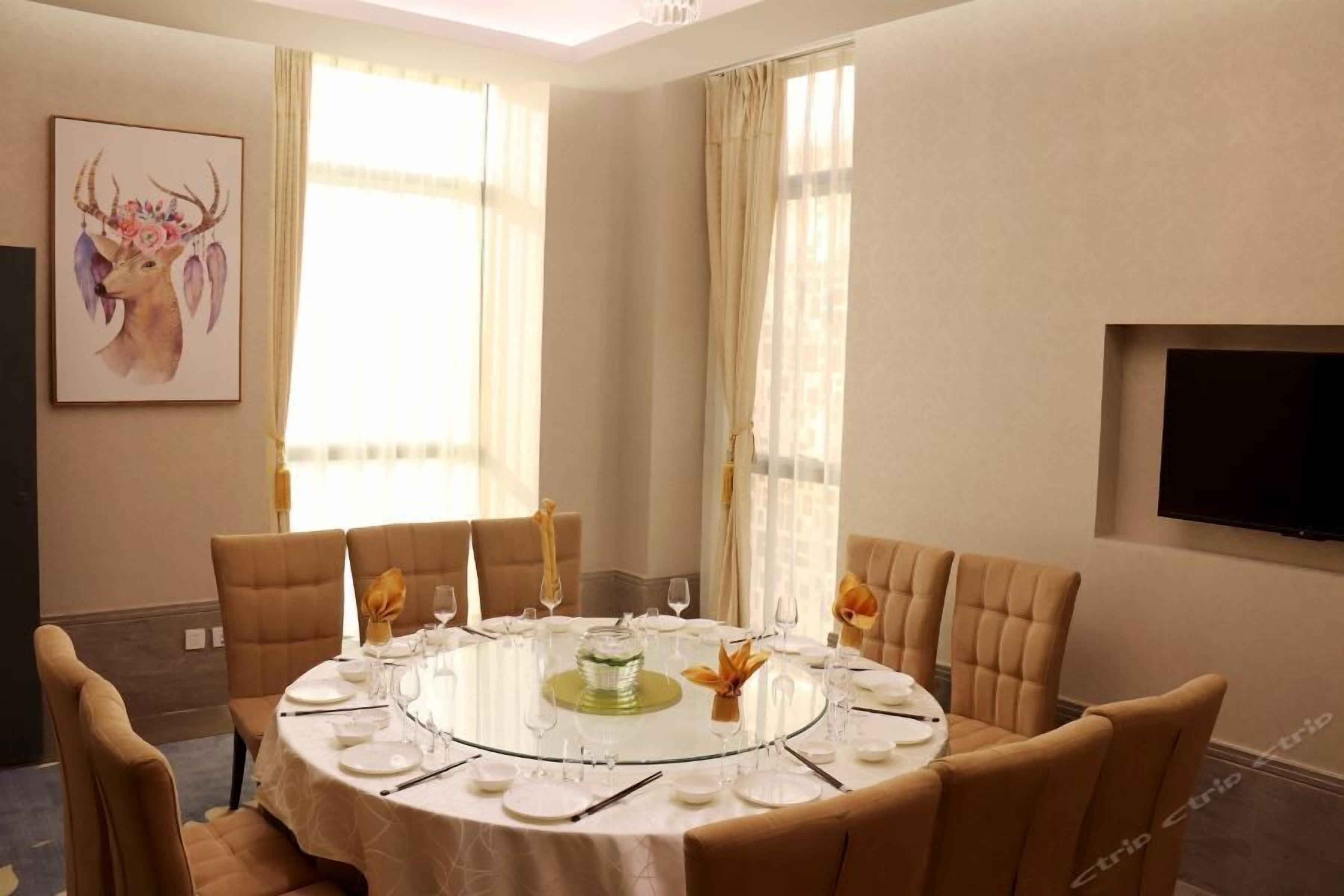 A dining area with a round table set for six, surrounded by upholstered chairs.