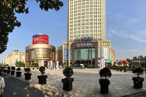 A hotel with a modern facade, a large entrance, and a prominent sign. - Hyattin Hotel (Wuhan)