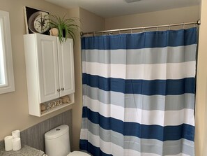 Bathtub, hair dryer, towels, toilet paper