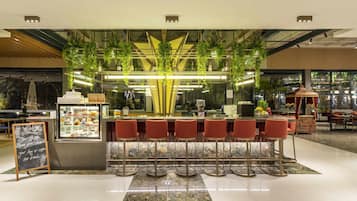 Un área de bar moderna con mostrador, taburetes y una pizarra.