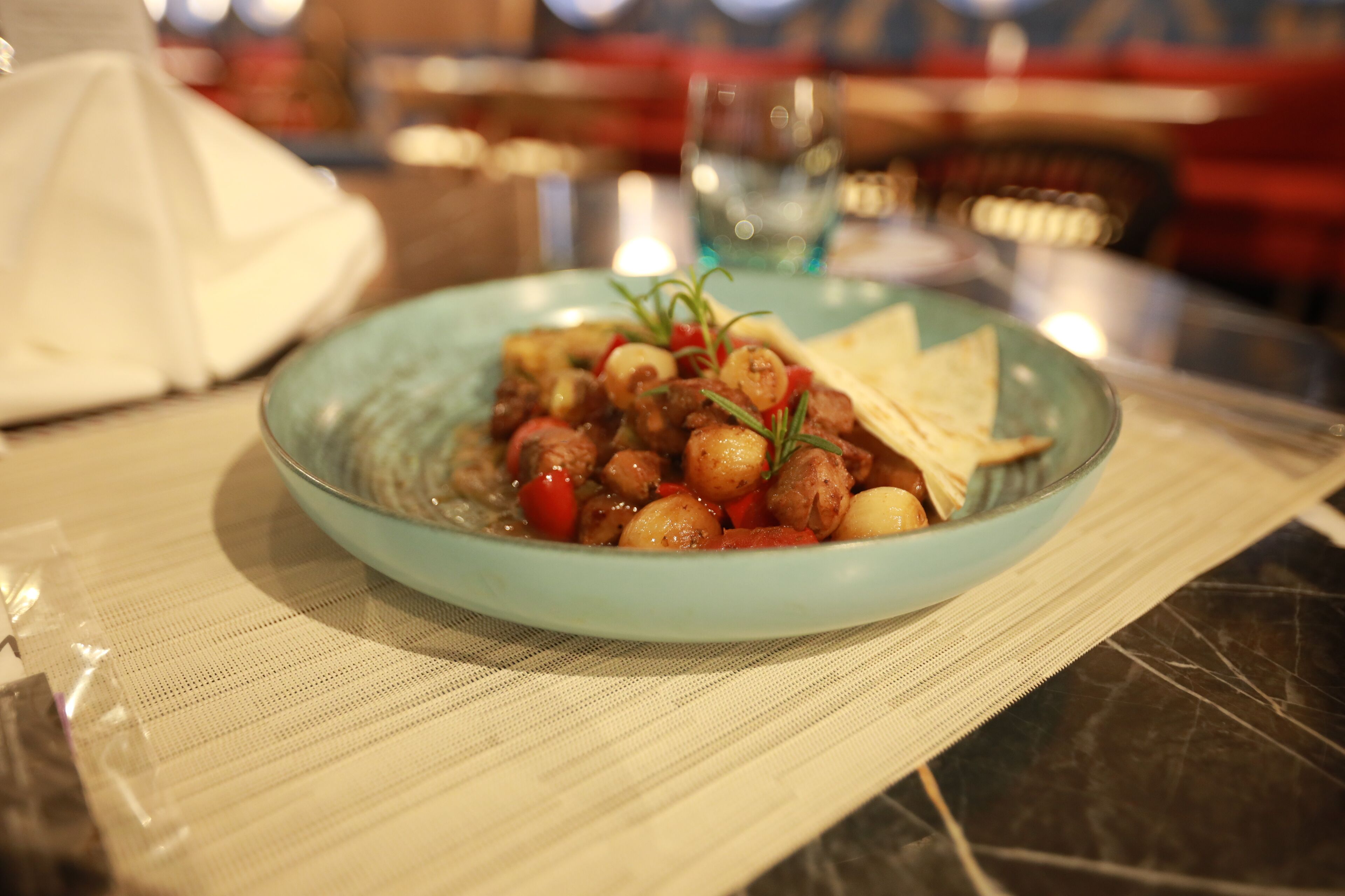 Un plato de comida sobre una mesa con un mantel individual.