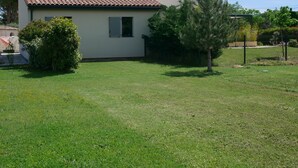 A single-story house with a tiled roof, a small front yard, and a tree. - 4* apartment facing the Luberon (Oppède)