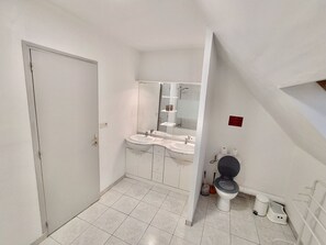 Un baño pequeño y funcional con inodoro, lavabo y espejo.