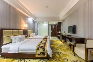 A hotel room with two beds, a TV, a desk, and a chair. - Gold Silver Dragon Hotel (Qiongshan)