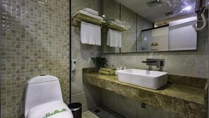 Een moderne badkamer met een wit toilet, een marmeren aanrechtblad en een grote spiegel.