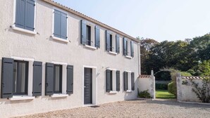 Un bâtiment à deux étages, doté de nombreuses fenêtres et d’une allée gravillonnée.