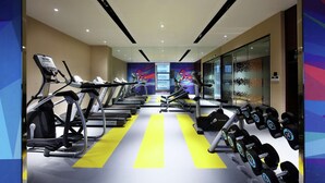 Un gimnasio con cintas de correr, mancuernas y equipamiento para ejercicios.