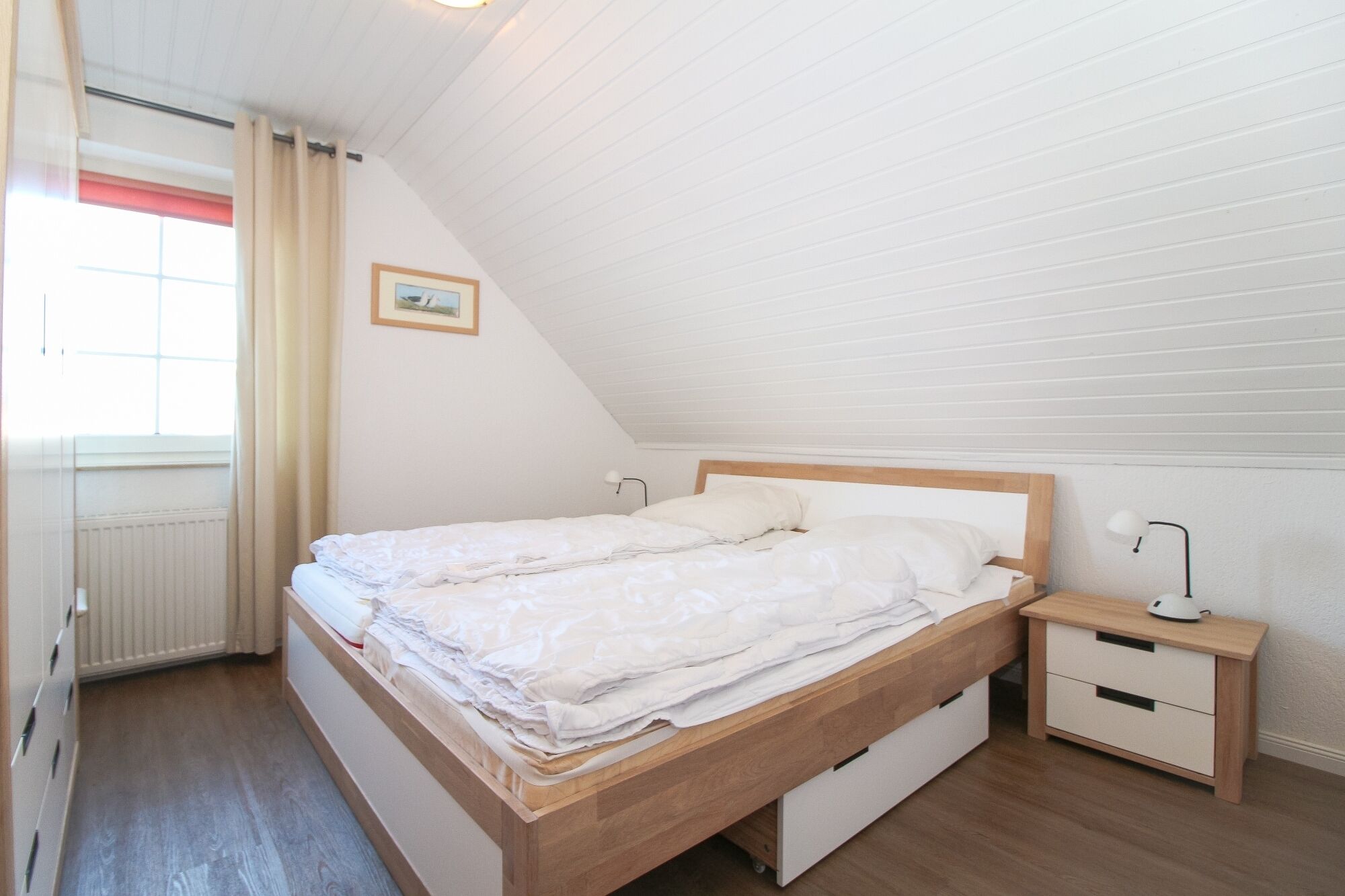 Un dormitorio con una cama de madera, una mesita de noche y un radiador.