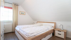 Un dormitorio con una cama de madera, una mesita de noche y un radiador.