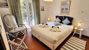A bedroom with a bed, a chair, a bedside table, and a view of the outdoors. - nice villa with with pool and seaview (agay)