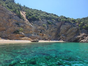 A coastal landscape with clear turquoise water, rocky cliffs, and sparse vegetation. - New holiday home with large terrace and private swimming pool (Golden Beach / Potamia)