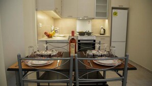 Une table dressée pour un dîner à deux, avec une bouteille de vin, des verres et des couverts.
