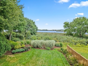 A well-maintained garden with a variety of plants and a wooden fence.