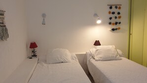 A room with two beds, a red lamp, a wall hanging, and a door. - Mazet Provençal Avec Magnifique vue mer (Sainte-Maxime)