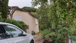 A white car parked in front of a house with a beige exterior, surrounded by dense greenery and a small garden area. - Mazet Provençal Avec Magnifique vue mer (Sainte-Maxime)