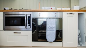 Une cuisine équipée d’un four à micro-ondes, d’un four et d’un lave-vaisselle intégrés.