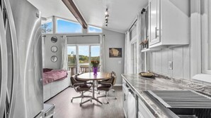 Una cocina moderna con zona de comedor, ventanas amplias y vistas al exterior.