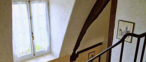 Una escalera con barandilla de madera y una ventana en la parte superior.