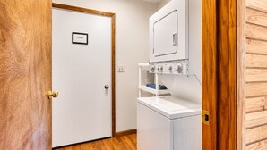 A laundry room with a white washing machine, a drying rack, and a door with a 'Laundry' sign. - Must see the Up Cabin in the Hideout (Lake Ariel)