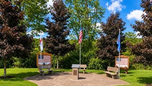 A memorial park with benches, flags, and plaques. - Must see the Up Cabin in the Hideout (Lake Ariel)