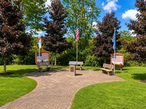 Ein Gedenkpark mit Bänken, Flaggen und Gedenktafeln.