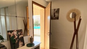 A well-lit hallway with a white console table, a large mirror, and a woven rug. - House Agosta plage- Terrace with sea view - Sea 500m - 10 people (Albitreccia)