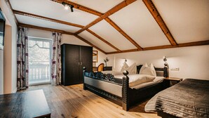 A bedroom with a sloped ceiling, a bed, a desk, and a wardrobe. - schoene Ferienwohnung-Wagrain (Wagrain)