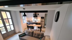 Una sala de estar moderna con un sofá, una mesa de comedor y una cocina al fondo.