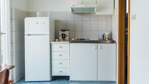 A compact kitchen with a refrigerator, a coffee maker, and a sink. - Beautiful apartment in Slatine with WiFi (Slatine)