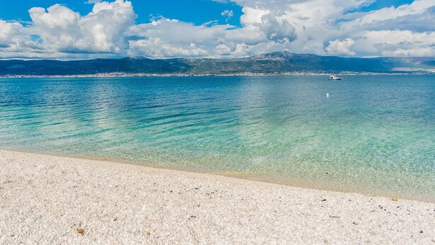A beach with clear turquoise water and a distant mountain range. - Beautiful apartment in Slatine with WiFi (Slatine)