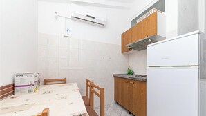 Una cocina compacta con un refrigerador blanco, armarios de madera y un salpicadero de azulejos.