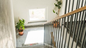 A staircase with a metal railing, a potted plant, and a window with natural light. - 1 bedroom beach front apartment in Slatine (Slatine)