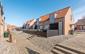 A residential area with houses featuring red-tiled roofs and brick exteriors.