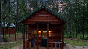 Une cabane en rondins appelée « Longhorn », dotée d’une véranda et de deux chaises.