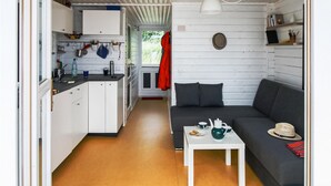 A compact living space with a kitchenette, a sofa, and a small table.